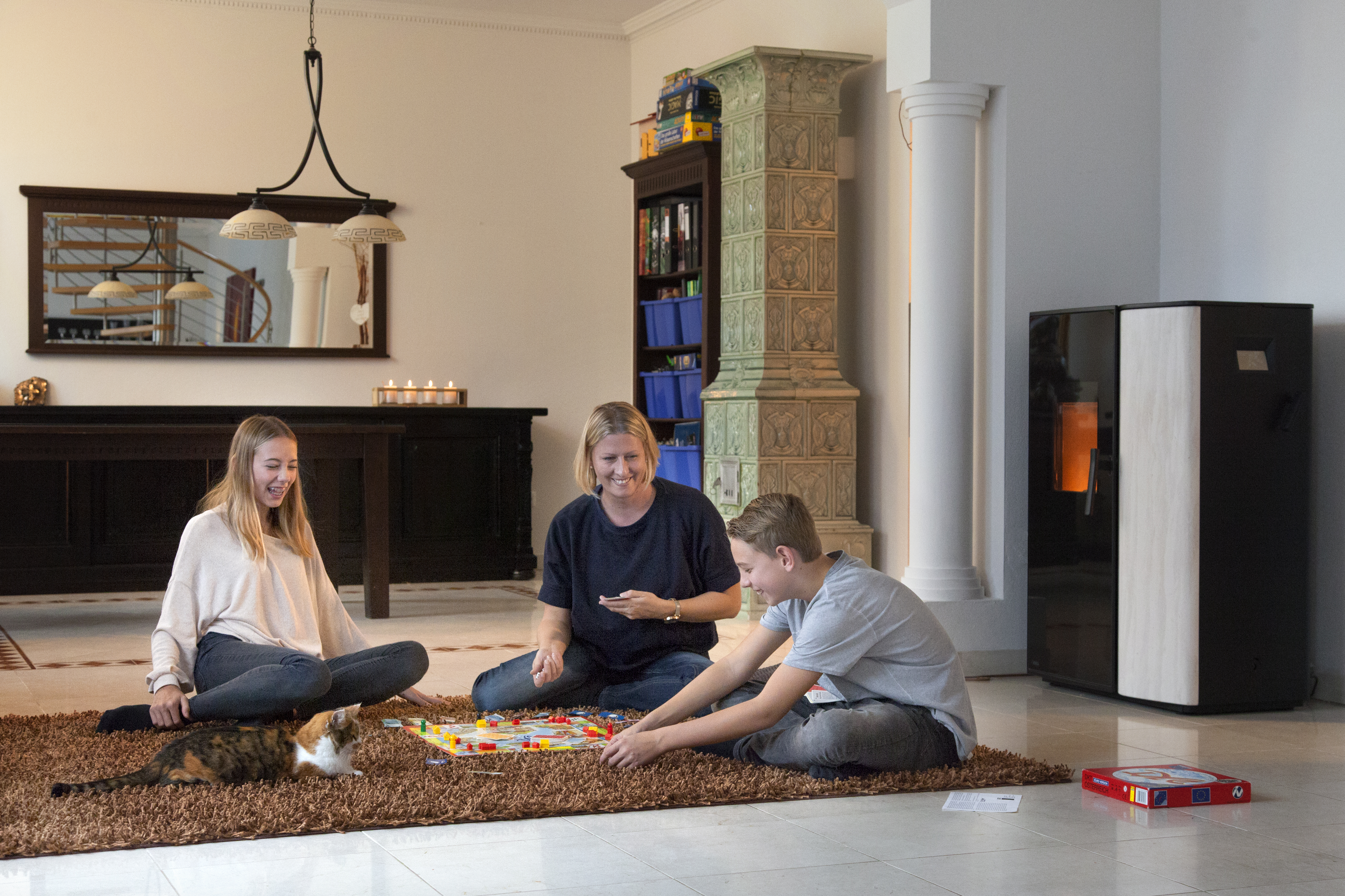 proPellets Pelletkaminofen Mutter spielt mit Kindern Brettspiel Katze